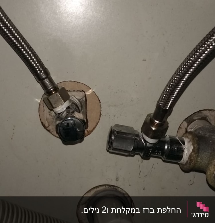 צינורות מתכת מחוברים לשסתומים בקיר